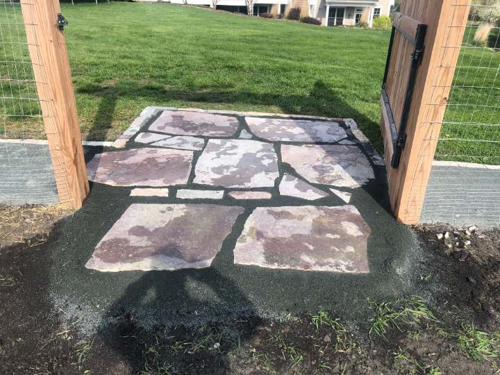 Flagstone pad laid in the opening of a garden gate
