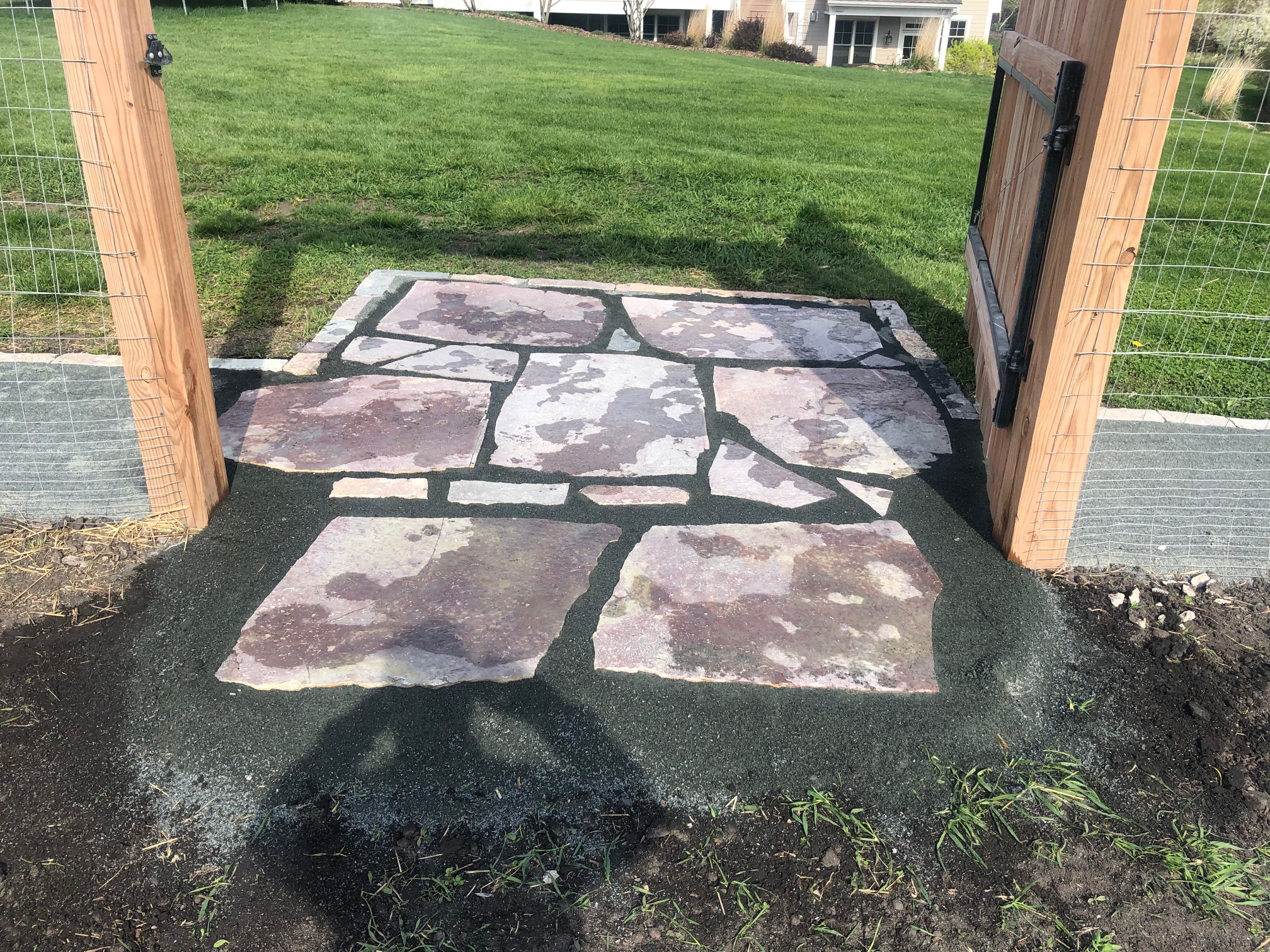 Flagstone pad laid in the opening of a garden gate